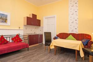 ein Wohnzimmer mit 2 Stühlen und einem Tisch sowie eine Küche in der Unterkunft Villa Atelier in Borkum
