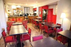 un ristorante con tavoli, sedie e pareti rosse di Arnaud Bernard Hôtel a Tolosa