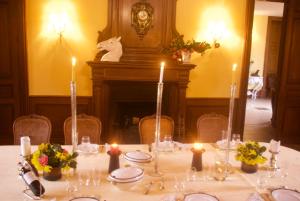 una mesa con velas, platos y flores. en Chateau De Piedouault en Jallais