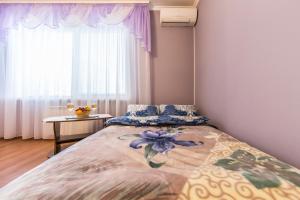 um quarto com uma cama grande e uma janela em Комфортная двухкомнатная квартира возле метро Академгородок em Kiev