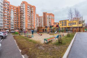 park z placem zabaw przed wysokimi budynkami w obiekcie Комфортная двухкомнатная квартира возле метро Академгородок w Kijowie