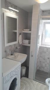 a bathroom with a sink and a washing machine at Apartment Upper Town in Gospić