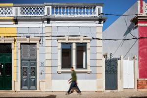 a person walking down a street in front of a building at Pereiras House of Charm - Downtown in Faro