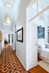 Un dormitorio con una cama blanca y suelo de madera. en Pereiras House of Charm - Downtown, en Faro