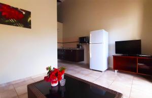 a living room with a white refrigerator and a table at Wayaca Mini Resort in Willemstad