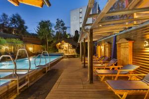 a swimming pool with lounge chairs next to a building at Hotel Am Bühl in Eibenstock