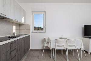 a kitchen with a table and chairs and a window at Apartment Tonka in Barbat na Rabu
