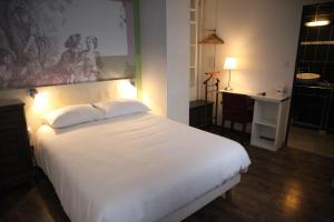 Ένα ή περισσότερα κρεβάτια σε δωμάτιο στο Arnaud Bernard Hôtel