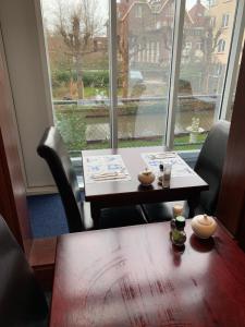 a table and chairs in a room with a window at Hotel Oorsprongpark in Utrecht