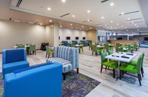 Holiday Inn - Amarillo East, an IHG Hotel في أماريلو: غرفة طعام مع طاولات وكراسي خضراء