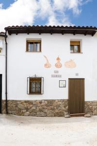 a white house with chickens on the side of it at Las Calabazas in Barrado