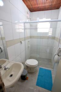 a bathroom with a white toilet and a sink at Villa Bali Maresias in Maresias