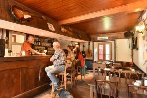 a group of people sitting at a bar in a restaurant at Auberge De La Providence in Saint-Donat