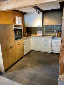 a kitchen with white cabinets and a tile floor at Ferienhaus Wisli in Triesenberg