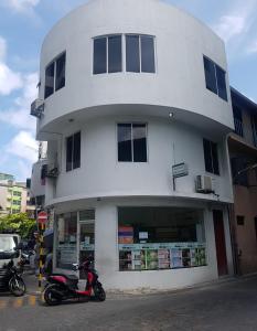 a scooter parked in front of a white building at Resting View in Male City