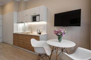 une cuisine avec une table blanche et un vase de fleurs dans l'établissement Apartamenty w Klaudynie, à Klaudyn
