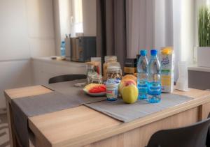 a table with bottles of water and fruit on it at Apartament Augustów SWAN in Augustów