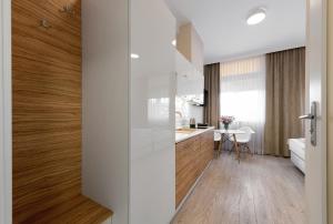 a kitchen with white walls and wooden floors at Apartamenty w Klaudynie in Klaudyn +108 photos