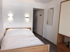 un letto in una camera con due luci sul muro di Les Jasmins a Beaulieu-sur-Mer