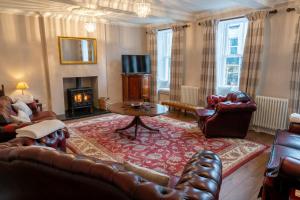 a living room with leather furniture and a fireplace at Forrest's Yard - Apartment 1 in Kendal