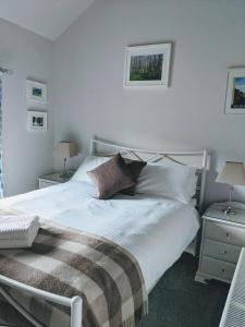 a bedroom with a large white bed and two lamps at Fell View, Slaggyford in Brampton