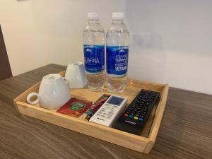 a tray with a bottle of water and a remote control at New Sky Airport Hotel in Noi Bai