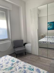 1 dormitorio con espejo, silla y cama en Affittacamere Vallesanta, en Levanto