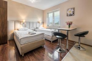 Pokój z 2 łóżkami, stołem i krzesłami w obiekcie Apartamenty w Klaudynie w mieście Klaudyn