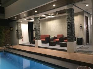 un vestíbulo con piscina y muebles en Andeo Suites en Ángeles