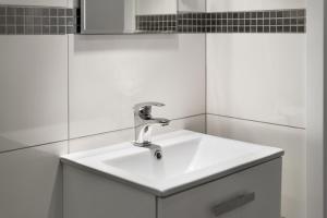 - un lavabo blanc dans la salle de bains aux murs blancs dans l'établissement Apartamenty w Klaudynie, à Klaudyn