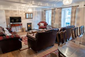 a living room with leather furniture and a fireplace at Forrest's Yard - Apartment 2 in Kendal