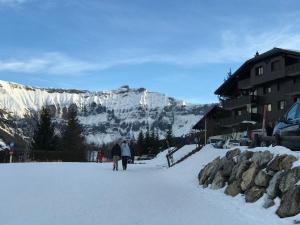ムジェーヴにあるAppartement Hameau des Pistes - Ski-in and Ski-outの山の前の雪歩き二人