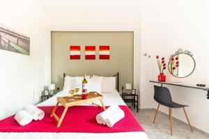 a bedroom with a bed with a red blanket and a table at Litsa's Suite in Heraklio