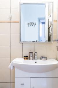 a bathroom with a white sink and a mirror at Litsa's Suite in Heraklio Town +48 photos
