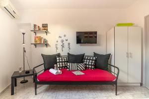 Habitación con sofá y manta roja. en Litsa's Suite en Heraclión