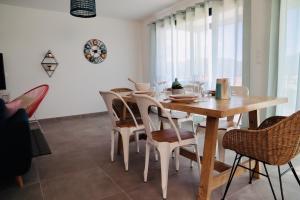 een eetkamer met een houten tafel en stoelen bij Très bel appartement avec grande terrasse in Porto-Vecchio