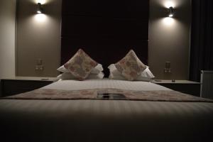 a bedroom with a large bed with white sheets and pillows at Lauriston & Lawton Court Hotel in Llandudno