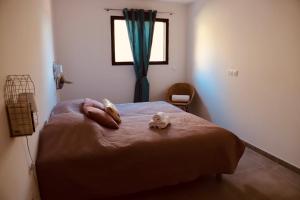een slaapkamer met een bed met 2 handdoeken en een raam bij Très bel appartement avec grande terrasse in Porto-Vecchio