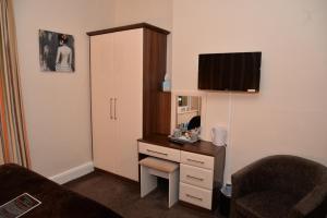 a room with a desk with a mirror and a chair at Lauriston & Lawton Court Hotel in Llandudno