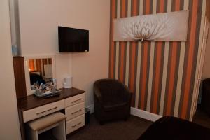a room with a desk and a chair and a mirror at Lauriston & Lawton Court Hotel in Llandudno