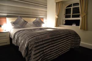 a bedroom with a large bed with a window at Lauriston & Lawton Court Hotel in Llandudno
