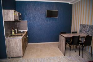 a kitchen with a table and a blue wall at Guest house Forest in Pyatigorsk