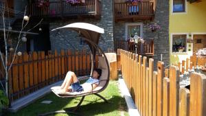 une femme assise dans une chaise roulante dans une cour dans l'établissement Relais du Paradis Chambres d'Hôtes, à Introd