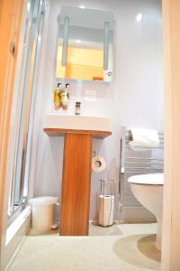 a bathroom with a sink and a mirror at Lauriston & Lawton Court Hotel in Llandudno