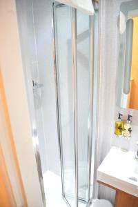 a bathroom with a shower and a toilet and a sink at Lauriston & Lawton Court Hotel in Llandudno