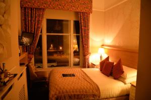 a hotel room with a bed and a window at Lauriston & Lawton Court Hotel in Llandudno