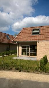 a brick house with a red roof at Vakantiehuisje Walhofpark 10 in De Panne