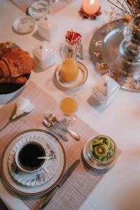 a table topped with plates of food and orange juice at Castel Jolly in Rennes