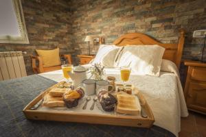 - un plateau de produits pour le petit-déjeuner sur un lit dans l'établissement Apartamentos Pumarin, à Santa Marina