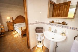 a bathroom with a sink and a bed at Apartamentos Pumarin in Santa Marina